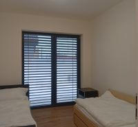 Bedroom with two beds and a wooden decor floor in a family house.