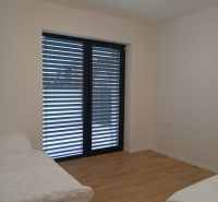 A room in a family house with a bed and a wooden decor floor.
