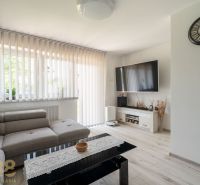 Living room in a family house with a sofa and television, floor with wooden decor.