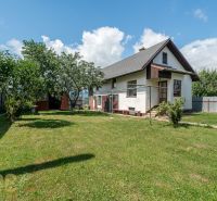 A family house on Športová Street in Hozelce with a lawn, trees, and a fence.