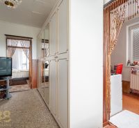 Interior of a family house with a television, mirrored wardrobe, and wooden bead curtains.