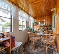 A pleasant terrace in a family house with rattan furniture and a wooden ceiling.