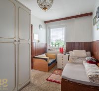 A room in a family house with a bed, storage space, and wall decorations.