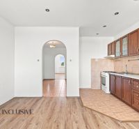 A kitchen in a 2-room apartment with a wooden decor floor and built-in cabinets.