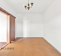 A room in a 2-room apartment with a wooden decor floor and sliding doors.