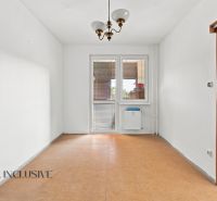 A spacious room with wooden decor, a white wall, and a light fixture in a 2-room apartment.
