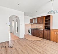 A kitchen in a 2-room apartment with a wooden decor floor and built-in cabinets.