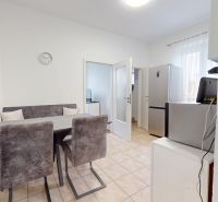 Kitchen with dining area and appliances in a 3-room apartment, tiled floor.