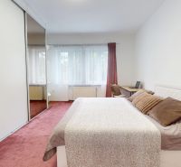 A bright bedroom with a large bed, a desk, a mirrored wardrobe, a 3-room apartment.