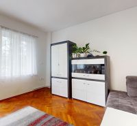Living room of a three-room apartment with a sofa, cabinets, and a wooden decor floor.