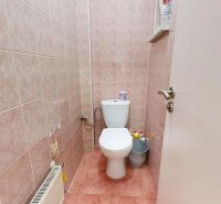 A toilet with orange tiles in a 3-room apartment.
