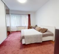 A bedroom in a 3-room apartment with a carpet, bed, and built-in wardrobe.