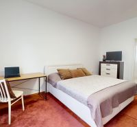 A bedroom in a 3-room apartment with a desk and white furniture.