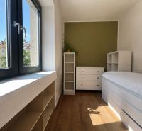 A cozy room with a wood-patterned floor in a 2-room apartment, overlooking the street.