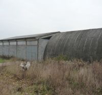 Warehouses and halls in Trnava with concrete structures and metal doors in a neglected environment.