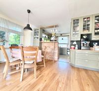 A kitchen in a family house with a wooden decor floor and wooden furniture.