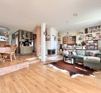 Interior of a family house with a kitchen, wood-decor flooring, and comfortable seating.