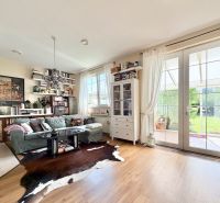 A living room in a family house with a wooden decor floor and a view of the garden.