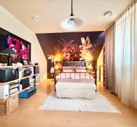 A bedroom in a family house with pink walls and a wooden decor floor.