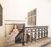 A staircase with a metal railing and an advertisement on the wall in commercial premises.