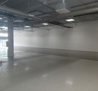 Spacious commercial spaces with concrete flooring and exposed pipes on the ceiling.