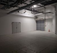 Empty commercial spaces with industrial equipment, white walls, and lights.
