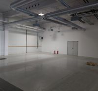 Empty industrial interior with concrete flooring and ventilation, commercial space.