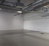Empty commercial spaces with suspended ceilings and ventilation.
