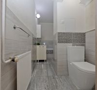 Bathroom of a two-room apartment with tiles and modern sanitary equipment.