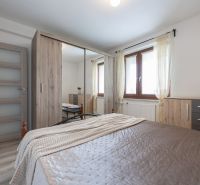 A bedroom in a two-room apartment with wooden furniture, a large window, and a floor with a wooden decor.
