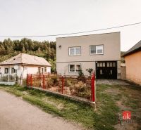 A family house in Radzovce near the forest with a simple garden and a red fence.