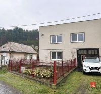 A family house in Radzovce with a neat garden and a lit fence.