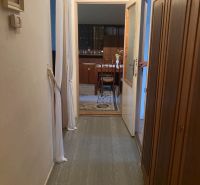 A hallway in a 3-room apartment with practical storage space and a view into the dining room.