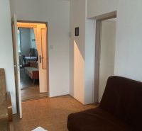 A room in a 3-room apartment with a view of the sofas and a wooden decor floor.