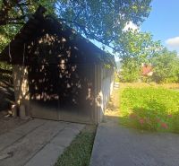 The exterior of a family house in Rožňava with a wooden extension and a green garden.
