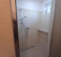 Shower enclosure with ceramic tiles in a family house.