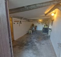 Basement of a family house with industrial pipes, lighting, and a work table.