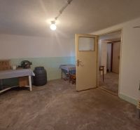 Interior of a family house with a bright room, a table, and storage containers.