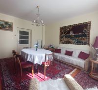 Living room with a red carpet, round table, and sofa in a family house.