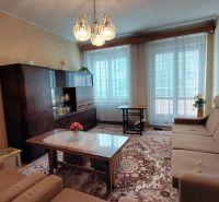 Living room in a 2-room apartment with antique furniture and floral decoration.