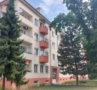 Apartment building with balconies surrounded by greenery on 28th October Street in Trenčín.