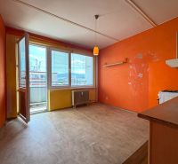 A kitchen in a 3-room apartment with orange walls and access to a balcony.