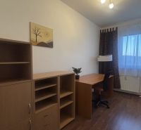 A study with a desk, chair, and shelves in a 3-room apartment with a wooden decor floor.