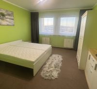 A bright bedroom with a double bed, green walls, and a wardrobe in a 3-room apartment.