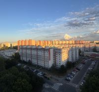 View of the housing estate in Bratislava - Petržalka from Mánesovo Square, surrounded by greenery and parking lots.