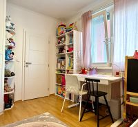 Children's room in a 3-room apartment with a wooden decor floor and a desk.
