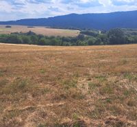 Extensive residential plots in Ostrá Lúka surrounded by green hills and meadows.