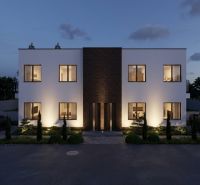 Illuminated facade of a two-story house with a symmetrical design in the village of Veľká Mača.