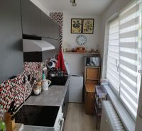 Cozy kitchen in a 2-room apartment with colorful tiles and a large window.