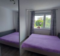 Bedroom in a 2-room apartment with a bed and a view from the window.